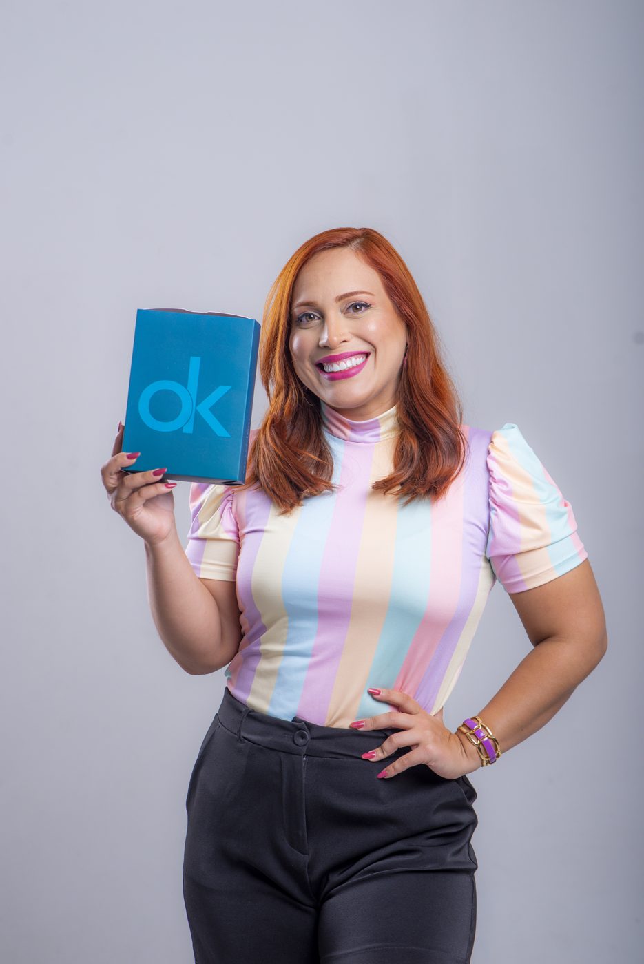Mulher sorrindo segurando a caixa Ortoklear